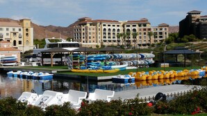 A marina with boats, a water park, and a hotel with multiple buildings and a mountain backdrop. - TRANQUIL SETTING IN 6TH FLOOR, 1 BEDROOM 1 BATH CONDO WITH BREATHTAKING VIEW  (Henderson)