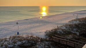 A beach with a wooden boardwalk and a person walking. - Wow!!!  Updated Beach front 4th top flr condo RIGHT on the beach (Destin)
