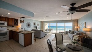 A spacious living area with a kitchen, dining area, and a balcony with a view of the ocean. - Wow!!!  Updated Beach front 4th top flr condo RIGHT on the beach (Destin)