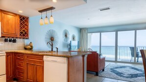 A modern kitchen with wooden cabinets, a built-in dishwasher, and a large island. - Wow!!!  Updated Beach front 4th top flr condo RIGHT on the beach (Destin)