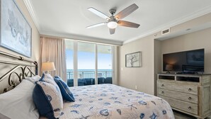 A bedroom with a bed, a television, a dresser, and a balcony with a view. - Luxury Oceanfront Condo, Jacuzzi Tub, Lazy River | Mar Vista Grande - 1110 (North Myrtle Beach)