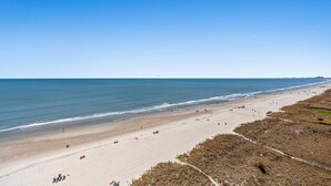 A wide beach with a clear sky and calm sea. - Luxury Oceanfront Condo, Jacuzzi Tub, Lazy River | Mar Vista Grande - 1110 (North Myrtle Beach)