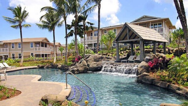 Ett semesterparadis med pool, palmer och ett vattenfall.