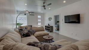 A modern living room with a beige sofa, a round coffee table, and a ceiling fan. - The Lofts #7 | Townhome Pool Resort | Poolside (Saint George)