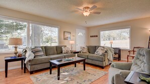 A living room with two sofas, a coffee table, and a ceiling fan. - Cute, Cozy & Comfortable Cottage Conveniently Located In The Heart Of Town.  (Oak Harbor)