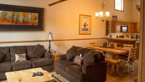 A cozy living room with a sofa, coffee table, and a painting on the wall. - 2 Bedroom 2 bath end unit pet friendly condo in the  (mammoth lakes)