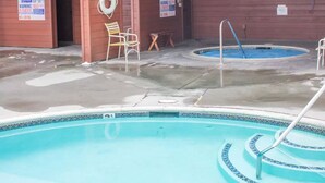 A swimming pool with a wooden deck and a covered area. There are two small pools and a chair near the entrance. - 2 Bedroom 2 bath end unit pet friendly condo in the  (mammoth lakes)