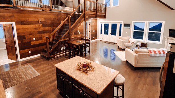 A spacious loft with a high ceiling, a wooden staircase, a dining area, and a living room with a fireplace. - PROMO 10% WEEKLY/20% MONTHLY DISCOUNT
SW Wisconsin, Hypoint’s Mississippi view (Eastman)