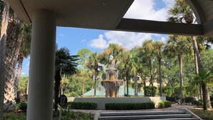 A covered outdoor area with a fountain, palm trees, and a paved walkway leading to a building. - STUNNING 2 BED 2 BATH SLEEPS 6 INCLUDES FREE GOLF/TENNIS WITH WESTIN AMENITIES (Hilton Head Island)