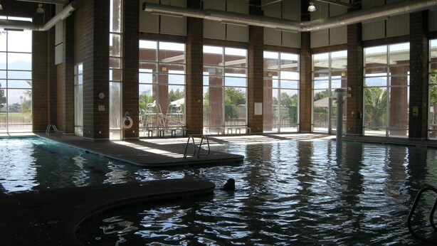 Una piscina interior con vistas despejadas al exterior a través de amplios ventanales.