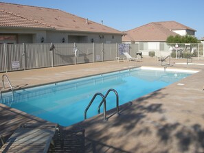 A swimming pool with a lifeguard chair and a no lifeguard on duty sign. - Mesquite Nevada Condominium Vacation Rental Ground Level (Mesquite)