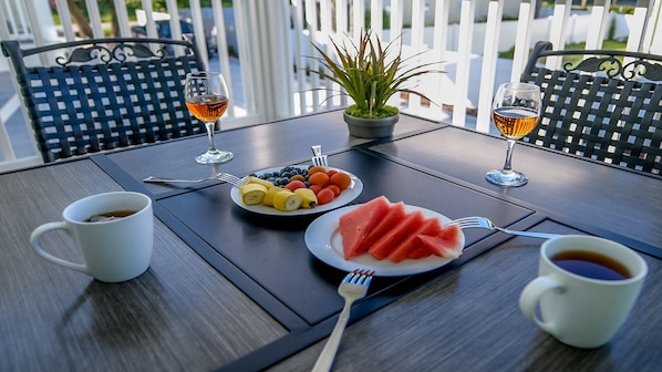 A table set with a plate of fruit, two glasses of a beverage, and a cup of coffee. - Gorgeous 3-BR, 3-Bath House- Steps to the Beach (Myrtle Beach)