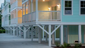 Una hilera de casas de campo frente al mar con balcones, numeradas 2200 y 2206, con fachada azul claro y barandillas blancas.