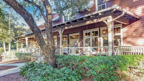 A wooden building with a covered porch, large windows, and a tree in front. - Turtle Dunes Oceanfront Ground floor 2br/2ba (Amelia Island)