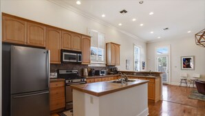 Una cocina moderna con armarios de madera, electrodomésticos de acero inoxidable y una isla central con pileta.