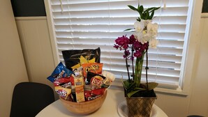 Ein Tisch mit einer Schale Snacks und einer Topf-Orchidee.