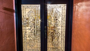 A black door with intricate glass designs and a metal handle.