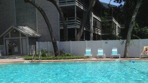 Ein Schwimmbecken mit Liegestühlen und einer gefliesten Terrasse.