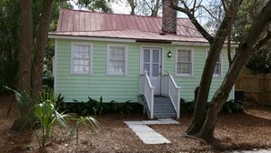 A small, single-story house with a red roof and white trim, a front porch with a single step, and a small front yard with pine straw and a few plants. - QUAINT COTTAGE IN HISTORIC OLD POINT   Beaufort, S.C. (Beaufort)