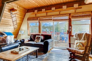 A cozy living room with a leather sofa, a wooden coffee table, and a view of the outdoors through large sliding glass doors. - Mountain Views, Hot Tub, Incredible Location! Dog Friendly!
BCA-47331 (Dillon)
