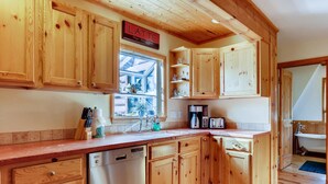 A kitchen with wooden cabinets, a dishwasher, a coffee maker, and a toaster. - Mountain Views, Hot Tub, Incredible Location! Dog Friendly! 
BCA-47331 (Dillon)