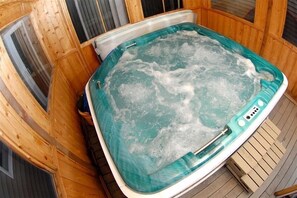 Relax in a hot tub surrounded by a cozy cabin atmosphere.