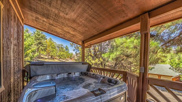 Un bain à remous sur une terrasse en bois, avec vue sur les arbres.