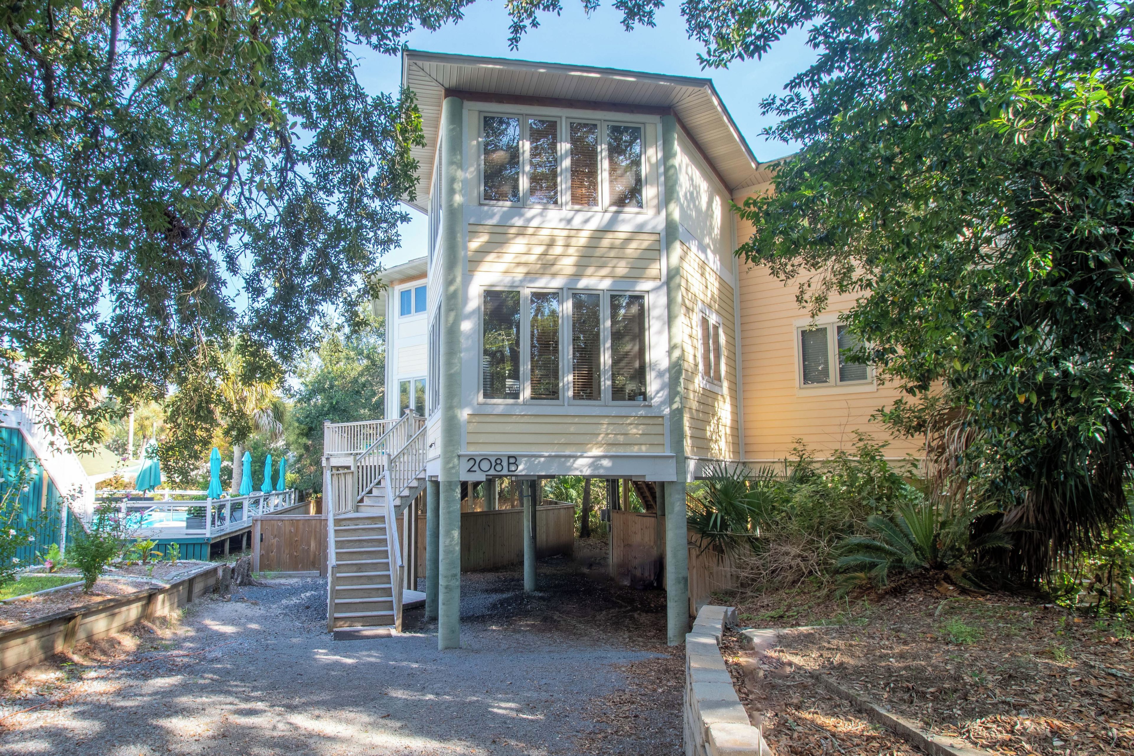 A two-story building with a balcony, a staircase, and a pool area.