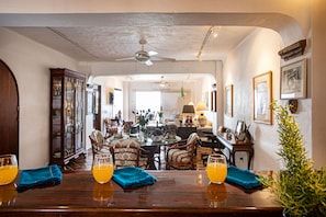 A dining area with a wooden table, chairs, and a ceiling fan.
