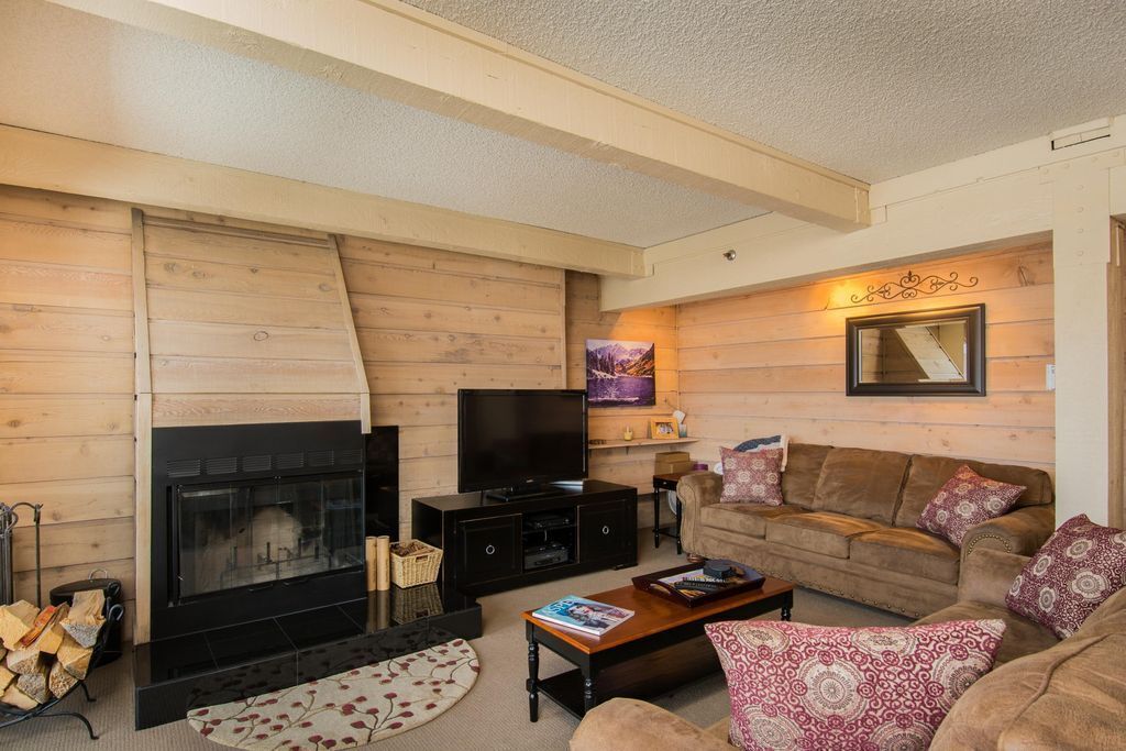 A cozy living room with a fireplace, a television, and comfortable seating.