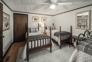 A bedroom with two wooden beds, a ceiling fan, and a large mirror. - Spacious Lodge with Stunning Views, Hot Tub, Game Room & Fireplaces | Minutes to Downtown Boone (Boone)