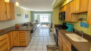 A kitchen with wooden cabinets, a sink, and a microwave. - Private Beach and Fishing Access, Walk out studio on the Emerald Coast! (Navarre)