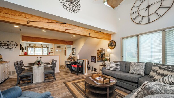 A spacious living area with a dining table, sofas, and a coffee table.