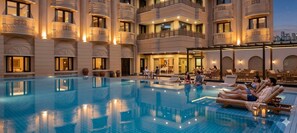 Un hôtel doté d’une grande piscine intérieure, de nombreux balcons et offrant une vue sur la ville.