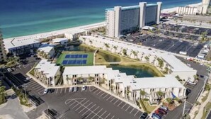 A coastal hotel with a large parking lot, a tennis court, and a pool. - Sept 15-19 Reduced! Steps to the Beach & Tootsies! (Panama City Beach)