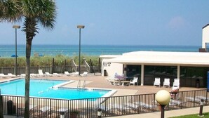A pool area with a view of the ocean, lounge chairs, and a covered seating area. - Sept 15-19 Reduced! Steps to the Beach & Tootsies! (Panama City Beach)