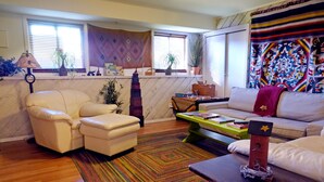 A cozy living room with a white sofa, a small table, and a colorful rug. - 1ST FLR APT Your Private Resort, now FAMILY-ized: 1 BR + LR suitable for 2 kids  (Shelton)