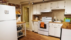 A modern kitchen with white cabinets, a stainless steel refrigerator, wooden countertops, and a built-in oven. - 1ST FLR APT Your Private Resort, now FAMILY-ized: 1 BR + LR suitable for 2 kids  (Shelton)