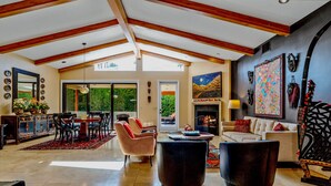 A spacious living room with a high ceiling, a fireplace, and a dining area with a large table and chairs. -  Gorgeous, Spacious Villa in Upscale Canyon Estates - Pool/Spa - Dog OK  (Palm Springs)