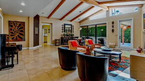 A spacious living room with high ceilings and exposed wooden beams, a large window, and a variety of seating options. -  Gorgeous, Spacious Villa in Upscale Canyon Estates - Pool/Spa - Dog OK  (Palm Springs)