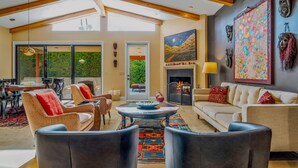 A spacious living room with a fireplace, comfortable seating, and a large window overlooking greenery. -  Gorgeous, Spacious Villa in Upscale Canyon Estates - Pool/Spa - Dog OK  (Palm Springs)
