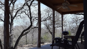 A covered outdoor area with wooden pillars, a ceiling fan, and a grill. - Allure charming peaceful wooded Hill Country like views with easy Lake access (eastland)