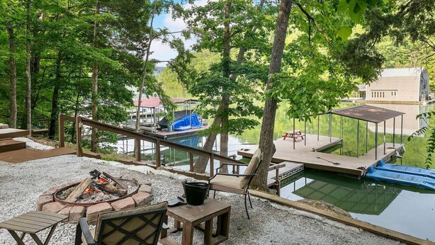 A backyard with a fire pit, outdoor seating, a pool, and a deck. - Lakeside Lodge – Private Dock, Hot Tub, Fire Pit & 8 Kayaks (Speedwell)