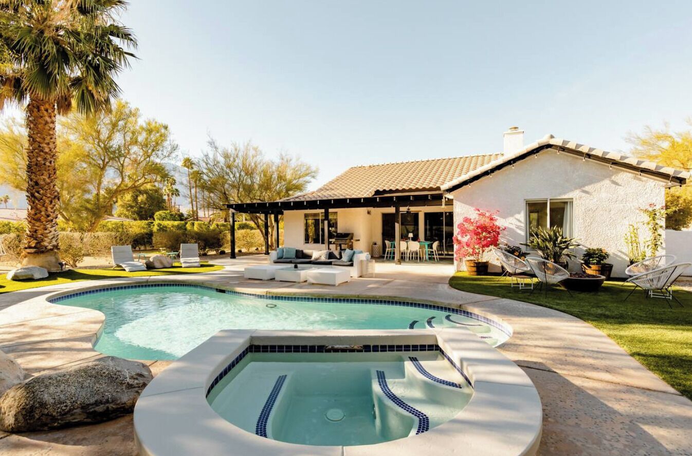 A house with a swimming pool, outdoor seating, and a patio area.