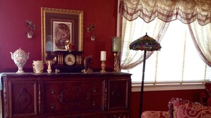 Ein traditionell eingerichtetes Zimmer mit einem hölzernen Schminktisch, einem gemusterten Sessel und einer dekorativen Lampe.