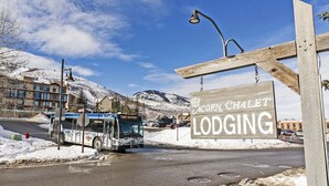 Un autobus sur une route, avec, au loin, un panneau indiquant le « Acorn Chalet Lodging ».