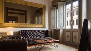 A living room with a large ornate mirror, a leather sofa, a coffee table, and a television. - CHARMING APARTMENT PIAZZA DEL POPOLO, 240 m2, 4 bedrooms, 9 sleeps, 2.5 bathr, (Rome)