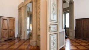 A hallway with wooden flooring, a large wooden door, and a white radiator with decorative panels. - CHARMING APARTMENT PIAZZA DEL POPOLO, 240 m2, 4 bedrooms, 9 sleeps, 2.5 bathr, (Rome)