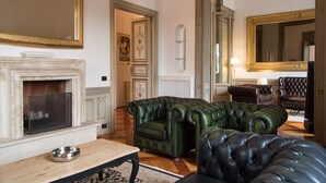 A traditional living room with a fireplace, leather armchairs, and a large mirror. - CHARMING APARTMENT PIAZZA DEL POPOLO, 240 m2, 4 bedrooms, 9 sleeps, 2.5 bathr, (Rome)