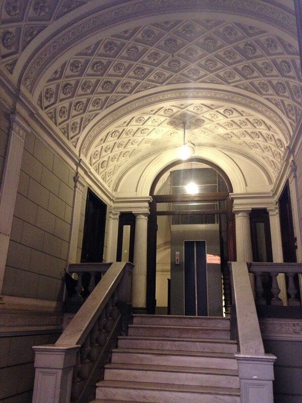 A grand staircase with a detailed ceiling and classical architecture.
